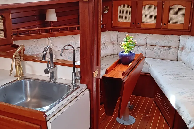 Slide: The Image of Interior of 1991 Gozzard 31 sailboat with cozy seating and compact kitchen area. - 31