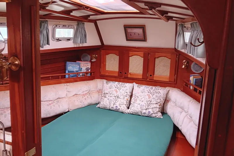 Slide: The Image of Cozy interior of 1991 Gozzard 31 sailboat with plush seating and wooden cabinetry. - 35