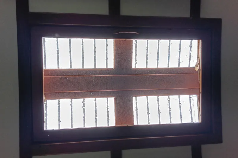 Slide: The Image of Skylight view from a 1991 Gozzard 31 boat, featuring wooden frame and metal bars. - 41