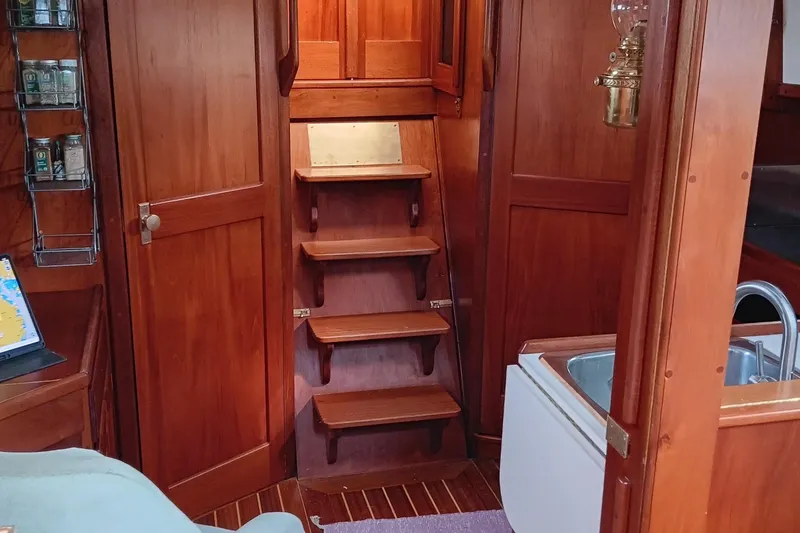 Slide: The Image of Interior of a 1991 Gozzard 31 sailboat with wooden stairs and cabinetry. - 42