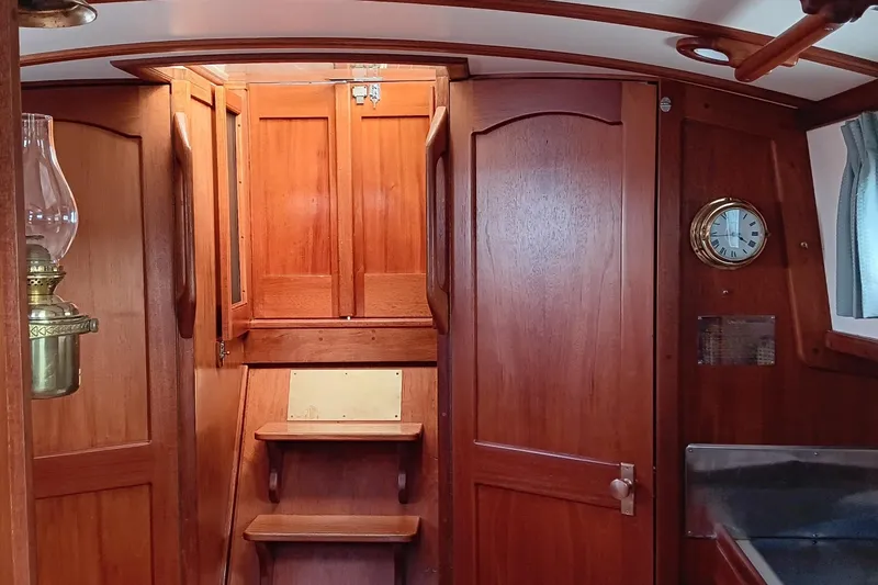Slide: The Image of Interior of 1991 Gozzard 31 sailboat with wooden cabinetry and brass clock. - 43