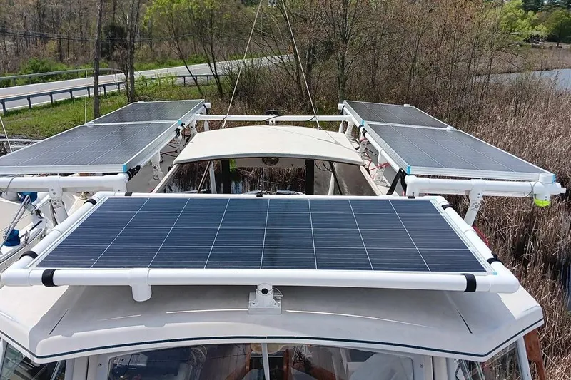 Slide: The Image of Solar panels on a 1991 Gozzard 31 boat, surrounded by lush greenery. - 55