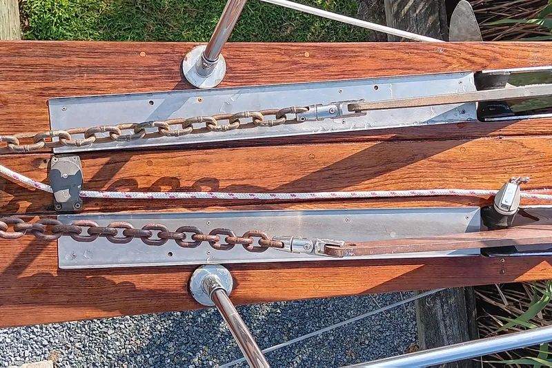 Slide: The Image of Deck hardware of a 1991 Gozzard 31 sailboat, featuring chains and ropes on wood. - 8