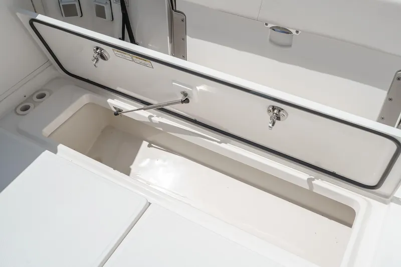 Slide: The Image of 2018 Boston Whaler 315 Conquest storage compartment with open hatch and secure latch. - 14
