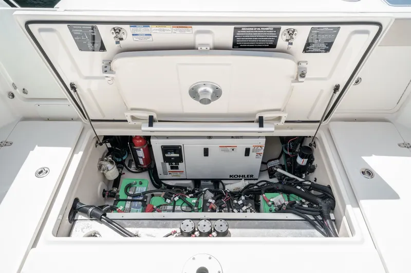 Slide: The Image of 2018 Boston Whaler 315 Conquest engine compartment with Kohler generator and wiring. - 15