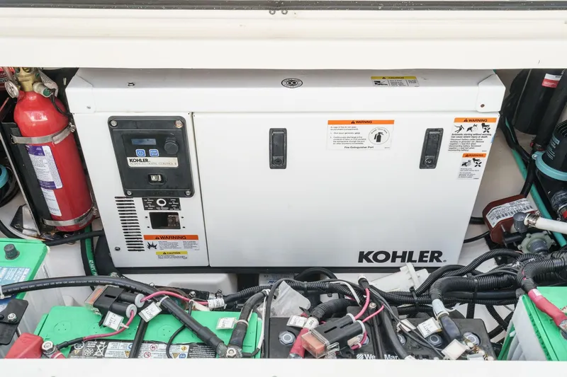Slide: The Image of Engine compartment of 2018 Boston Whaler 315 Conquest with Kohler generator and fire extinguisher. - 16
