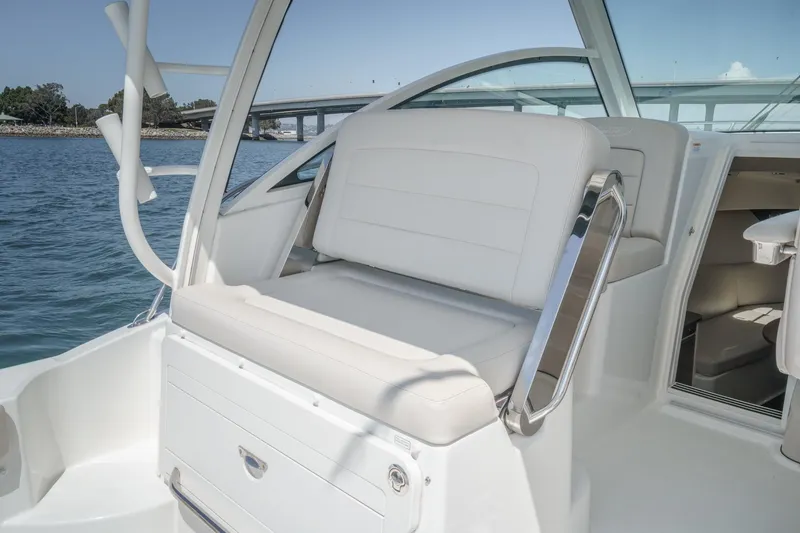 Slide: The Image of 2018 Boston Whaler 315 Conquest boat interior with white seating and ocean view. - 22
