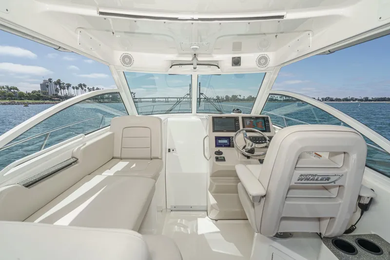 Slide: The Image of 2018 Boston Whaler 315 Conquest interior with helm, seating, and ocean view. - 24