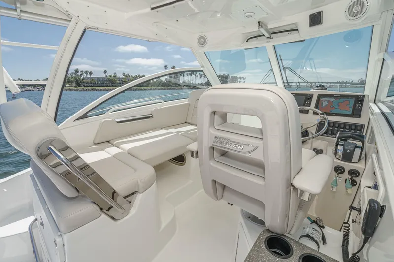 Slide: The Image of 2018 Boston Whaler 315 Conquest interior with helm, seating, and navigation equipment. - 25