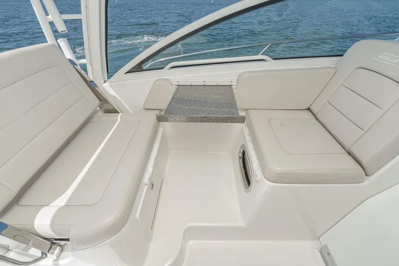Slide: The Image of 2018 Boston Whaler 315 Conquest interior seating with table, overlooking the ocean. - 27
