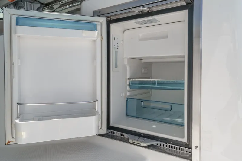 Slide: The Image of Open refrigerator on 2018 Boston Whaler 315 Conquest boat, showcasing interior storage space. - 32