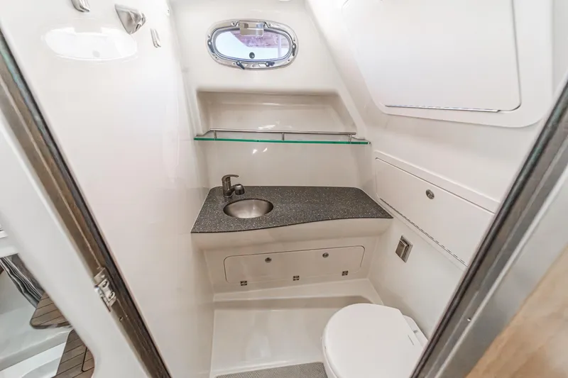 Slide: The Image of 2018 Boston Whaler 315 Conquest bathroom with sink, toilet, and porthole window. - 40