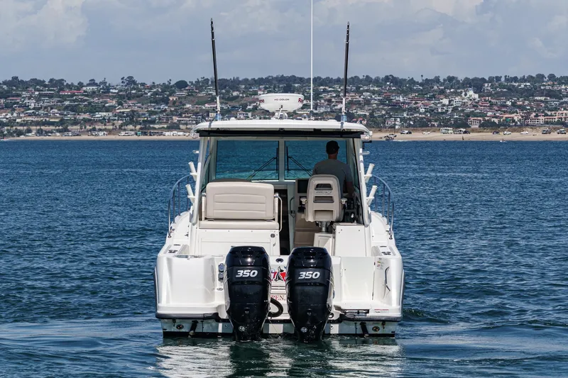Slide: The Image of 2018 Boston Whaler 315 Conquest boat on water, dual 350 engines, coastal background. - 5