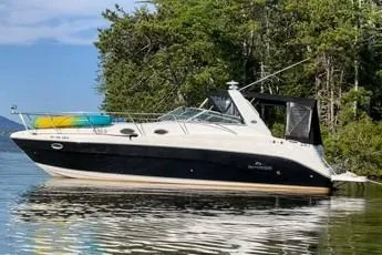 Slide: The Image of 2006 Rinker Fiesta Vee 342 boat docked by lush green trees. - 1