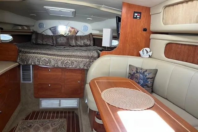 Slide: The Image of 2006 Rinker Fiesta Vee 342 interior with cozy bed, wooden cabinetry, and dining area. - 16