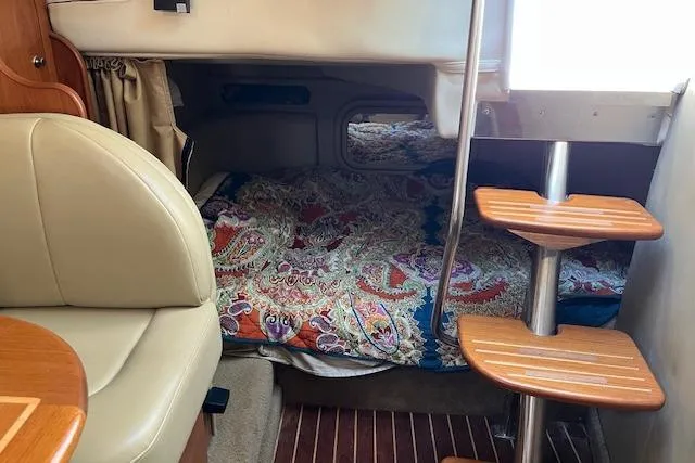 Slide: The Image of Interior of 2006 Rinker Fiesta Vee 342 boat with cozy sleeping area and wooden steps. - 3