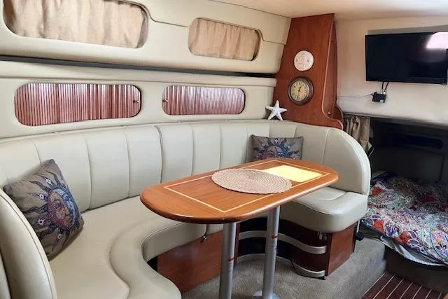 Slide: The Image of Interior of 2006 Rinker Fiesta Vee 342 boat with cozy seating and wooden table. - 4
