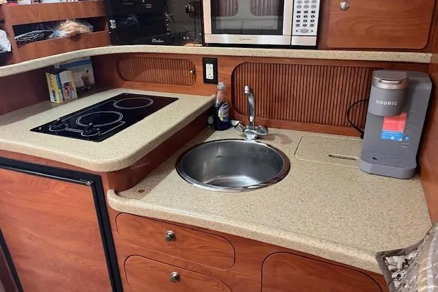 Slide: The Image of 2006 Rinker Fiesta Vee 342 boat kitchen with stove, sink, and microwave. - 7