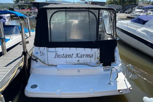 Slide: The Image of 2006 Rinker Fiesta Vee 342 boat named "Instant Karma" docked at a marina. - 9