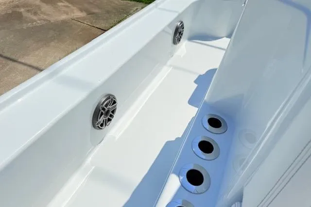 Slide: The Image of 2026 Yellowfin 24 Bay CE boat engine with dual power poles, parked on grass. - 16