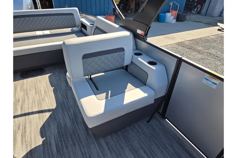 Slide: The Image of 2026 Godfrey AquaPatio 255 SFL boat interior with cushioned seating and cup holders. - 13