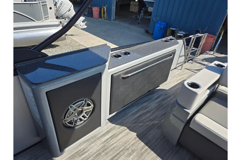 Slide: The Image of 2026 Godfrey AquaPatio 255 SFL boat interior with speaker and cup holders. - 22