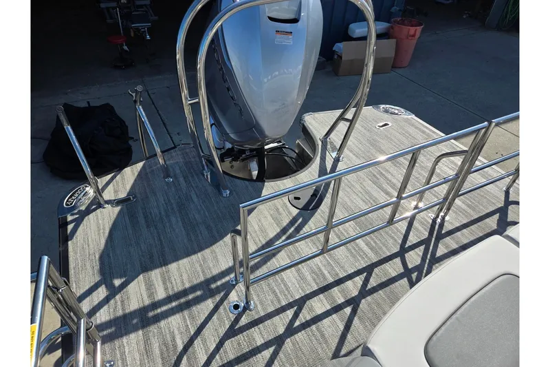 Slide: The Image of 2026 Godfrey AquaPatio 255 SFL boat deck with stainless steel railings and motor. - 26
