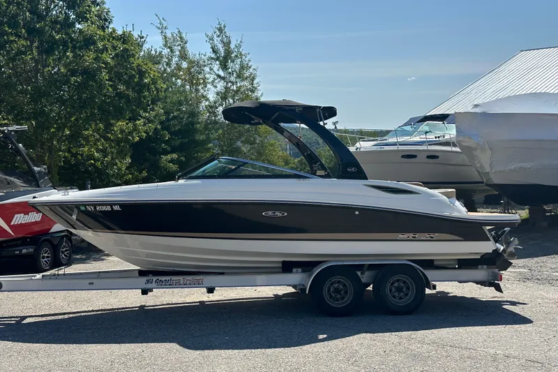 Slide: The Image of 2015 Sea Ray 230 SLX boat on trailer, parked outdoors. - 1