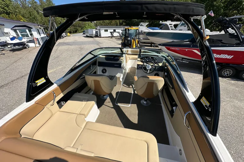 Slide: The Image of 2015 Sea Ray 230 SLX boat interior with tan seating and sleek dashboard. - 10