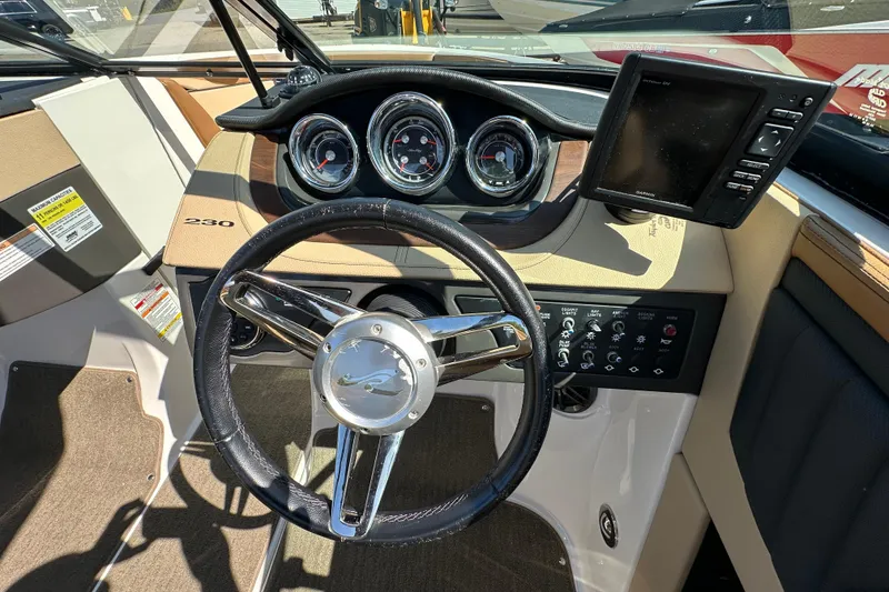 Slide: The Image of Interior dashboard of a 2015 Sea Ray 230 SLX boat with steering wheel and gauges. - 14