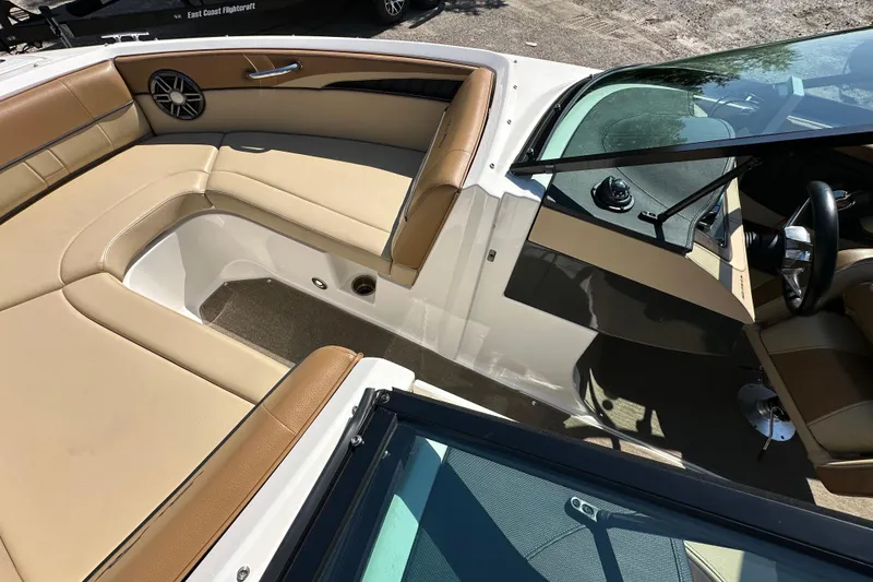 Slide: The Image of 2015 Sea Ray 230 SLX boat interior with tan seating and sleek dashboard design. - 19