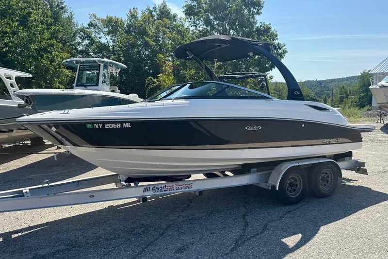Slide: The Image of 2015 Sea Ray 230 SLX boat on trailer, parked outdoors in sunny setting. - 2