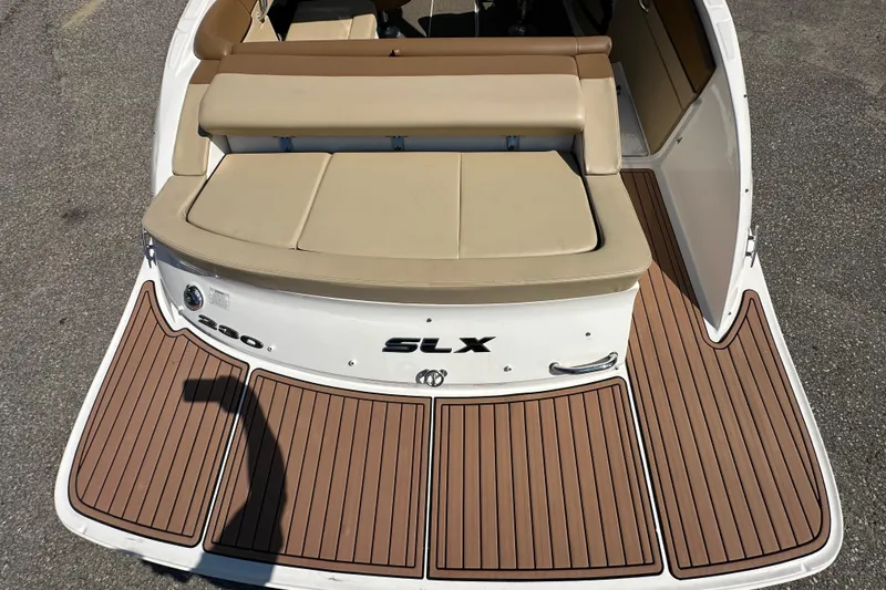 Slide: The Image of 2015 Sea Ray 230 SLX boat with tan seating and wood-patterned deck. - 9