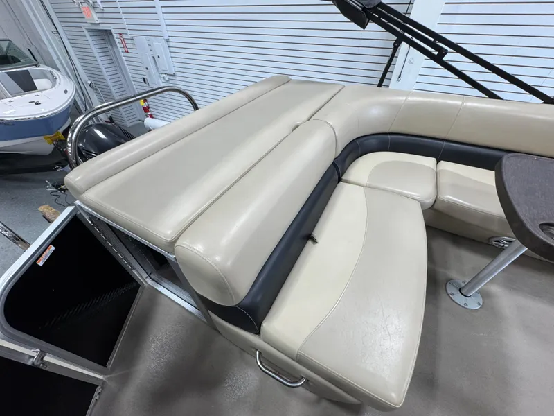 Slide: The Image of 2018 Manitou 21 Aurora LE Standard boat interior with beige seating and table. - 10