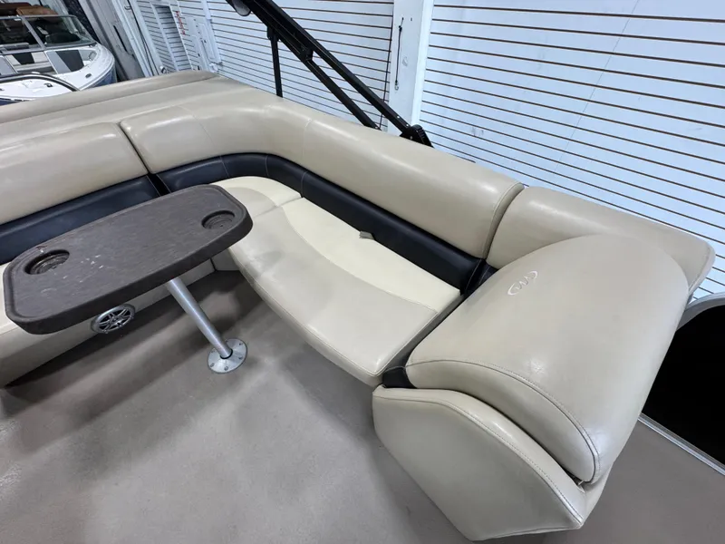 Slide: The Image of 2018 Manitou 21 Aurora LE Standard boat interior with beige seating and table. - 11