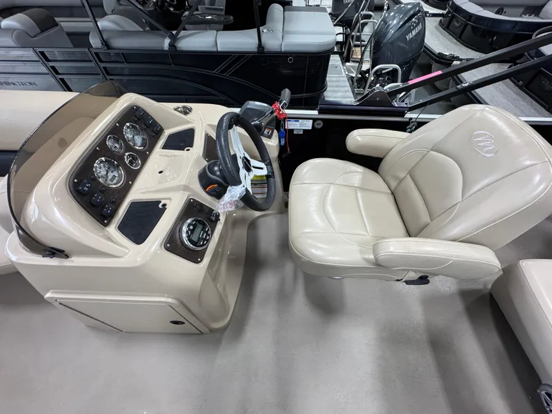 Slide: The Image of 2018 Manitou 21 Aurora LE Standard boat cockpit with steering wheel and beige captain's chair. - 12