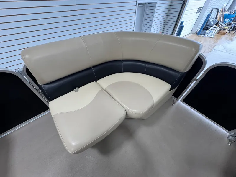 Slide: The Image of 2018 Manitou 21 Aurora LE Standard boat interior seating, beige and black upholstery. - 18