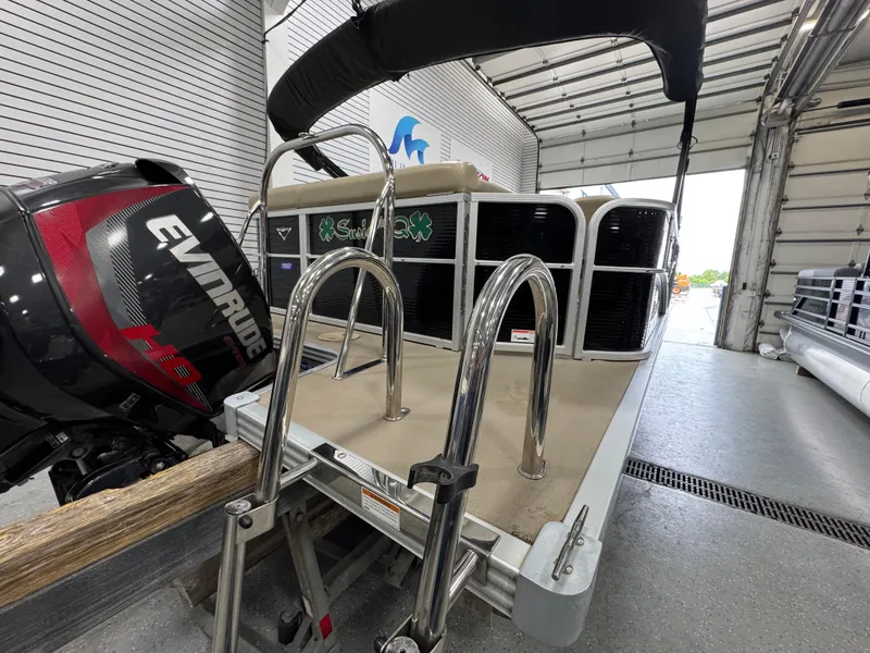 Slide: The Image of 2018 Manitou 21 Aurora LE Standard boat with Evinrude motor in a garage. - 7