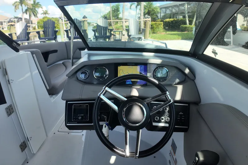 Slide: The Image of 2022 Four Winns HD8 boat dashboard with steering wheel and navigation display. - 11