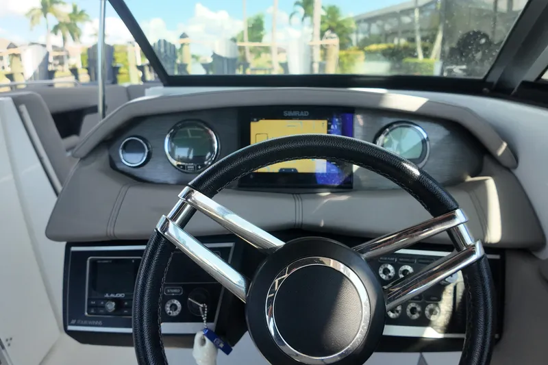 Slide: The Image of 2022 Four Winns HD8 boat dashboard with steering wheel and navigation display. - 12