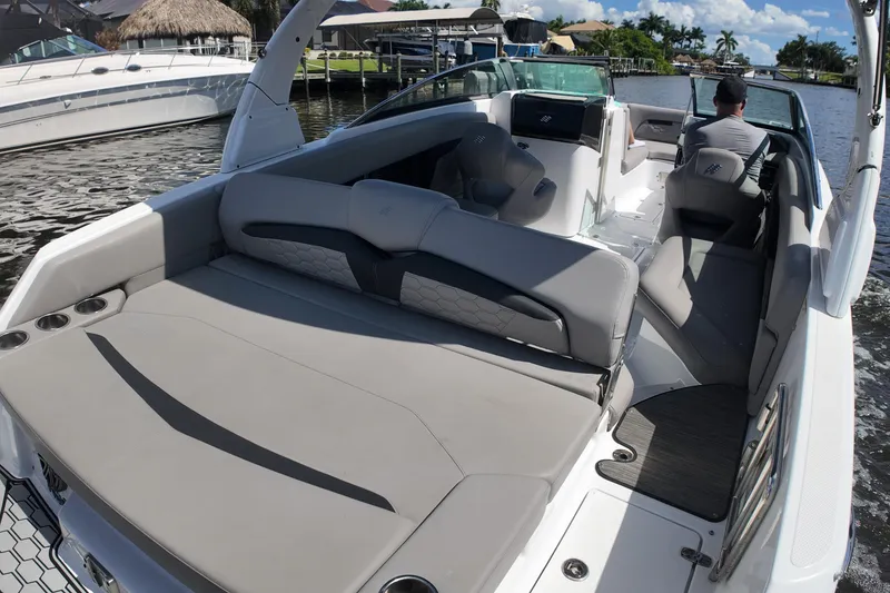 Slide: The Image of 2022 Four Winns HD8 boat interior with spacious seating and modern design on a sunny day. - 18