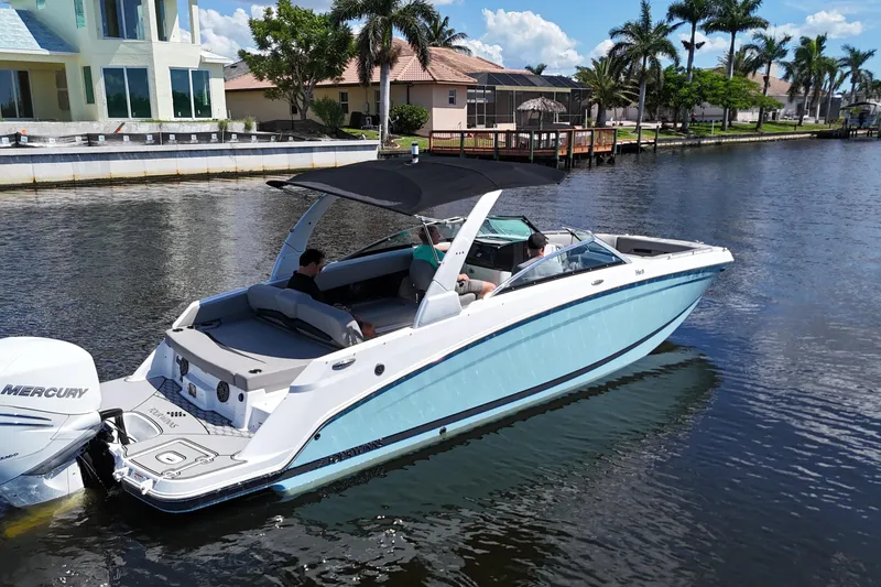 Slide: The Image of 2022 Four Winns HD8 boat cruising on a sunny canal with palm trees. - 4