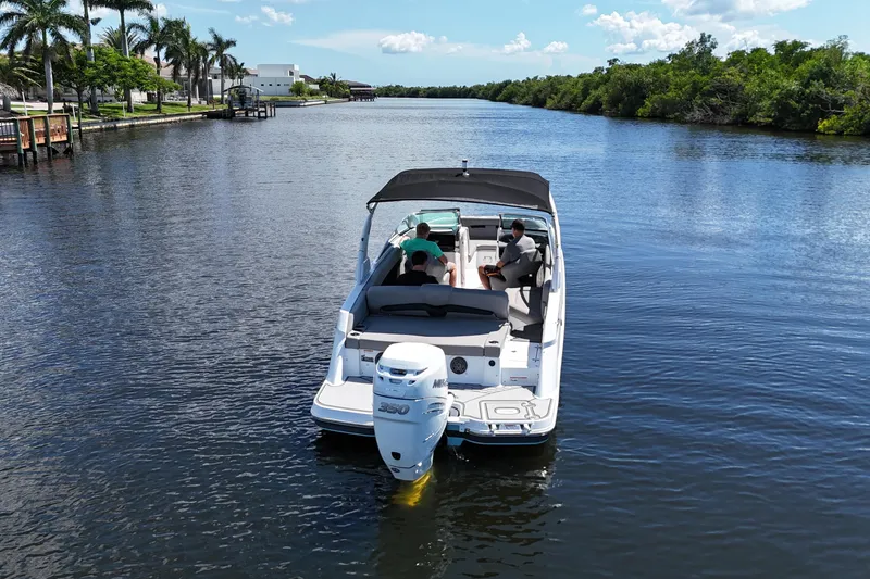 Slide: The Image of 2022 Four Winns HD8 boat cruising on a scenic river with passengers onboard. - 6