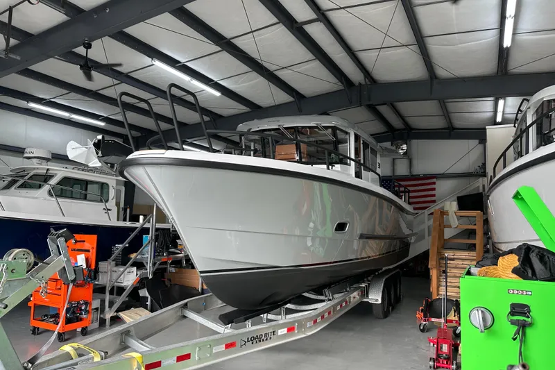 Slide: The Image of 2025 Sargo 31OB boat lifted by forklift in a shipyard setting. - 1