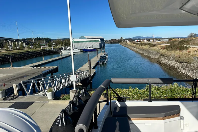 Slide: The Image of 2025 Sargo 31OB boat deck with cushioned seating and railing in a marina setting. - 10