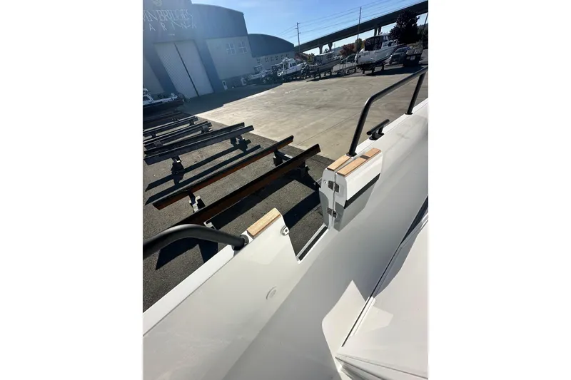 Slide: The Image of 2025 Sargo 31OB boat docked at marina with trailers in background. - 16