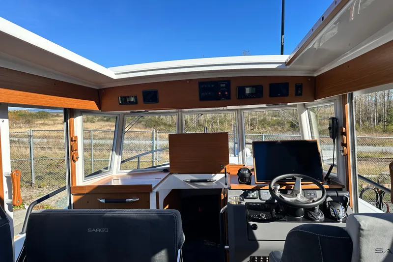 Slide: The Image of Interior of 2025 Sargo 31OB boat with modern navigation equipment and steering wheel. - 21