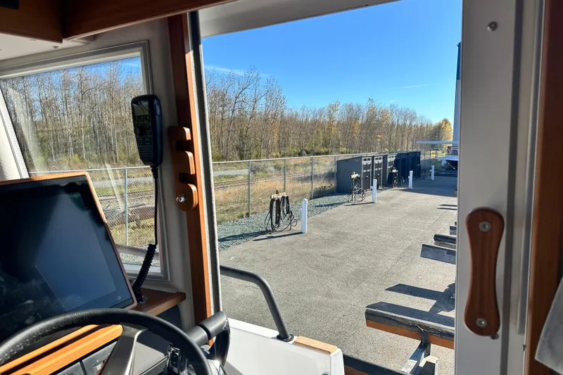 Slide: The Image of Interior view of 2025 Sargo 31OB boat, showing dashboard and outdoor marina scene. - 35