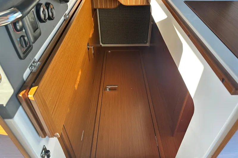 Slide: The Image of Interior view of 2025 Sargo 31OB boat, featuring wooden cabinetry and control panel. - 39