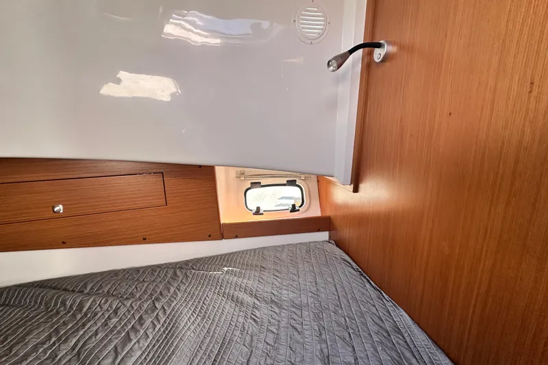 Slide: The Image of Interior cabin of 2025 Sargo 31OB boat with wooden paneling and a cozy bed. - 43